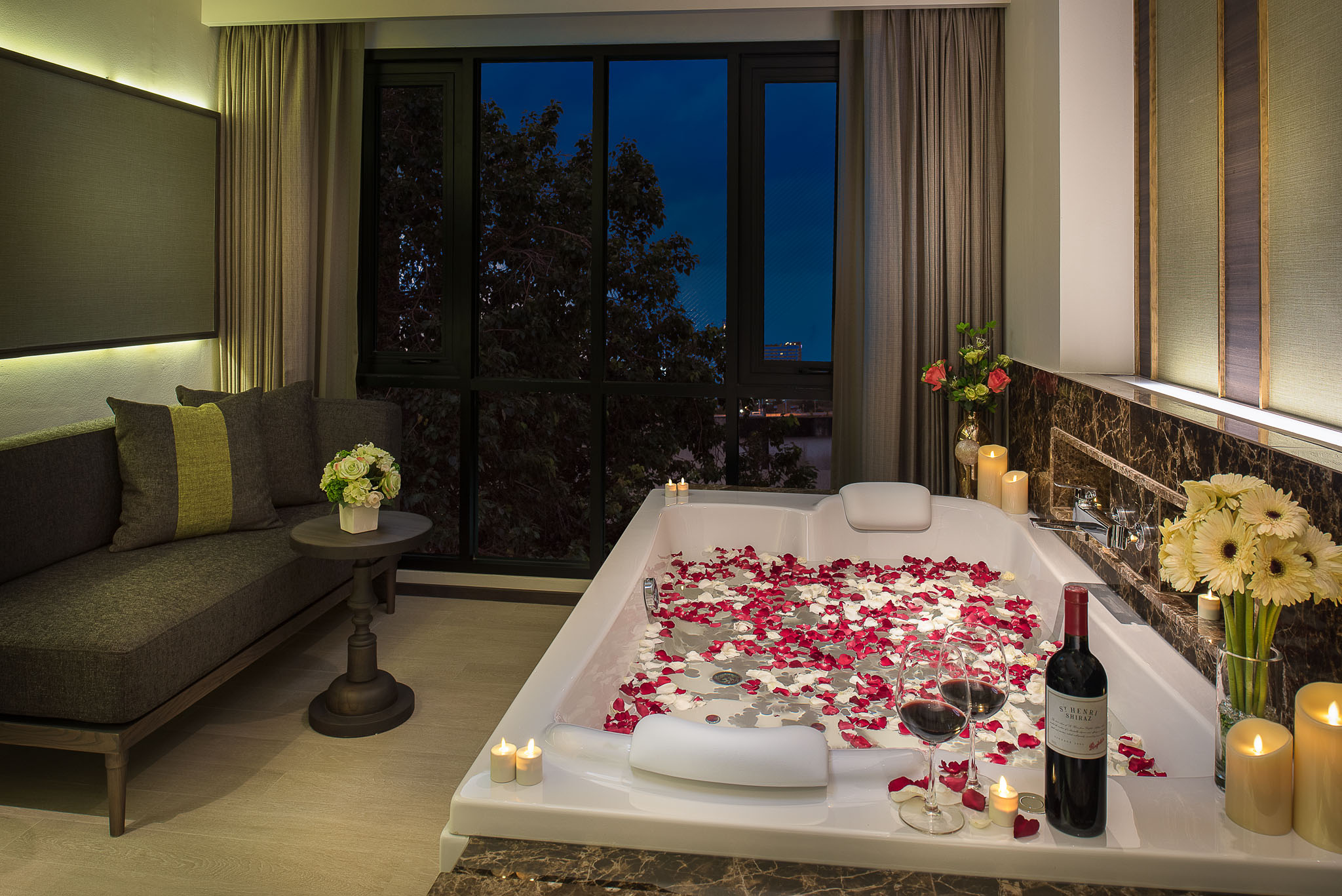 Private jetted bathtub prepared with rose petals